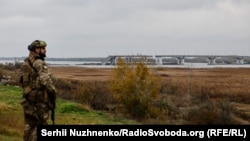 Український військовий з деокупованої правобережної Херсонщини дивиться на лівий берег області та розбитий Антонівській міст 