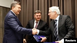 Після підписання угоди в Давосі 24 січня 2013 року: Віктор Янукович (л) потискає руку керівникові Royal Dutch Shell Петерові Фозеру (п), за ними спостерігає міністр енергетики та вугільної промисловості Едуард Ставицький (с), який підписав угоду з українського боку