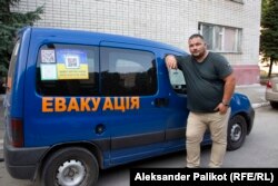 Illya Borsuk stands next to the vehicle he uses to evacuate people from hot spots in the Donbas.