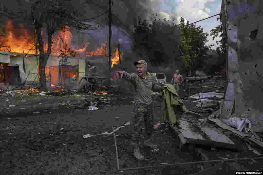 Украинский военнослужащий кричит парамедикам перед телами погибших в результате ракетного обстрела продовольственного рынка в центре Константиновки. Украина, 6 сентября 2023 года. (AP Photo/Evgeniy Maloletka)