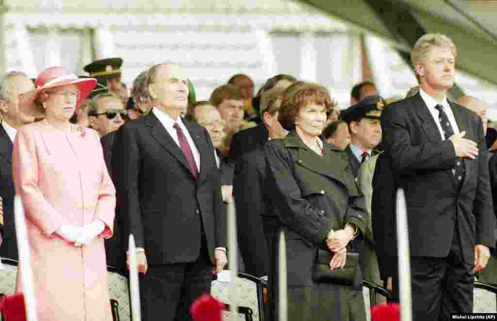 6 iunie 1994 - La ceremoniile Zilei Z care marchează cea de-a 50-a aniversare au participat președintele francez de atunci Francois Mitterrand (al doilea la stânga) și soția sa, Danielle (a doua de la dreapta), cărora li s-a alăturat Regina Elisabeta a II-a a Marii Britanii (stânga) și președintele american Bill Clinton (dreapta). În observațiile pe care le-a făcut a doua zi, Clinton a spus: „Imperiul Sovietic a dispărut”, în timp ce i-a lăudat pe ruși, polonezi și pe alții pentru participarea la eliberarea Europei. În această perioadă, NATO s-a extins și în Europa de Est, subliniind angajamentul Statelor Unite față de securitatea europeană.