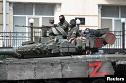 Бойовики приватної групи найманців «Вагнер» на броньованій машині на вулиці біля штабу Південного військового округу в місті Ростові-на-Дону, Росія, 24 червня 2023 року