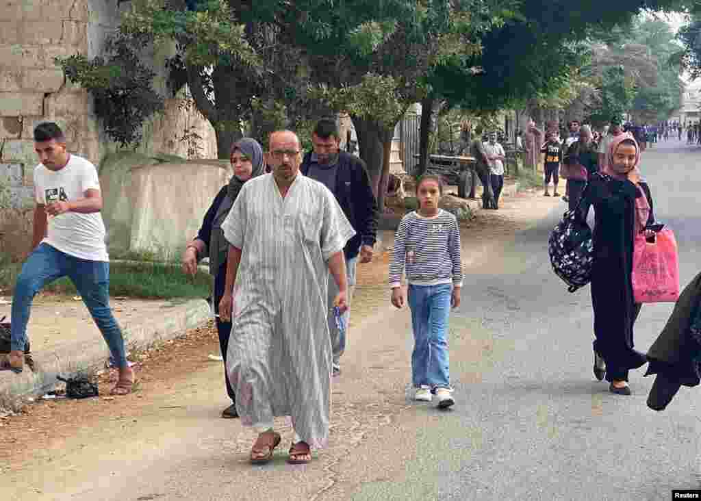 چند شهروند فلسطینی ساکن غزه در حال خروج از خانه‌ها همزمان با حملات هوایی اسرائیل به غزه
