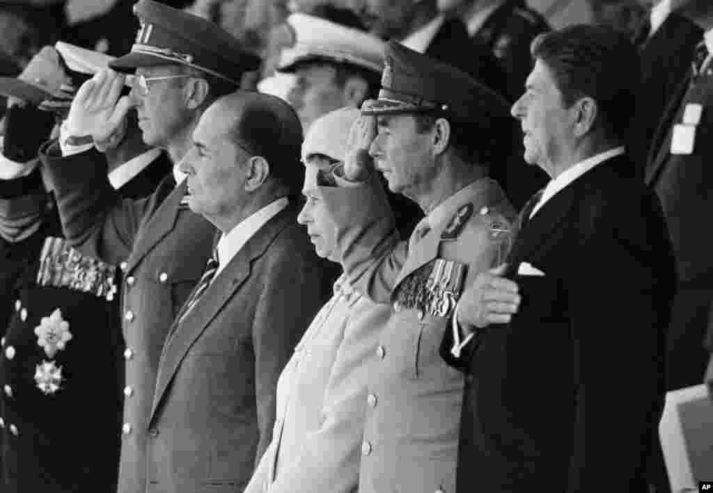 6 iunie 1984 în Normandia - de la stânga: regele Olav al Norvegiei, regele Baudouin al Belgiei, președintele francez Francois Mitterrand, regina Elisabeta a II-a a Marii Britanii, Marele Duce Jean de Luxemburg și președintele SUA Ronald Reagan ascultă imnurile din timpul comemorării a 40 de ani de la debarcarea de Ziua Z. Discursul lui Reagan de la Pointe du Hoc a fost conceput nu numai ca un tribut adus eroismului bărbaților care au luat cu asalt plajele, ci a fost văzut și ca o declarație simbolică care întărește angajamentul SUA față de principiile libertății și democrației pe fundalul Războiului Rece.