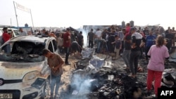 Palestinieni se adună la locul unei lovituri israeliene asupra taberei de refugiați în Rafah. 27 mai 2024.