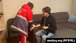 A medic treats Kazakh journalist Daniyar Moldabekov after he was attacked in his apartment building in Almaty on February 22.