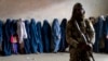 Talibanski borac stoji na straži dok žene čekaju da dobiju obroke hrane koje dijeli grupa humanitarne pomoći u Kabulu, 23. maj 2023. Od preuzimanja vlasti u augustu 2021., talibani su ponovo uspostavili jednu od najrigidnijih politika rodne diskriminacije u svijetu.
