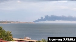 Smoke rises over the Kerch Strait from a fire in the Russian port of Kavkaz after a Russian fuel ferry was hit in a missile strike on August 22.