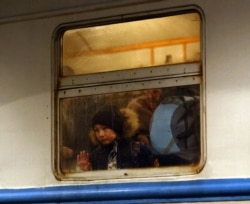 Un copil ucrainean așteaptă să coboare dintr-un tren plecat din Liov și care a ajuns în gara Przemysl Glowny, Polonia, 20 martie 2022.