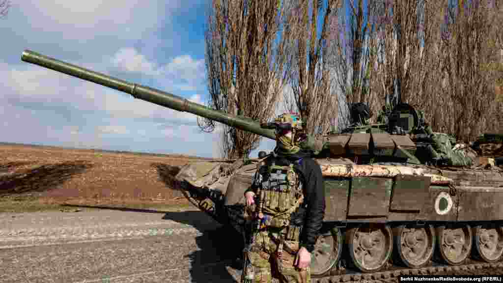 Український військовий стоїть поруч із захопленим у бою російським танком Т-72 