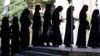 Afghan female students queue for entrance exams at Kabul University on October 13. The Taliban has issued restrictions controlling women's lives, blocking girls from returning to secondary schools and barring women from many government jobs.