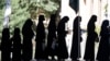 Female Afghan students stand in line after arriving for Kabul University's entrance exams on October 13.