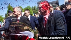 Russia's ambassador to Poland, Sergei Andreyev (right), was doused with red paint by participants of a protest against Russia's invasion of Ukraine during his attempt to lay flowers at a cemetery in Warsaw on May 9.