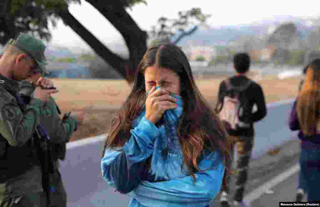 A woman reacts to tear gas near the Generalisimo Francisco de Miranda Air Base in eastern Caracas. 