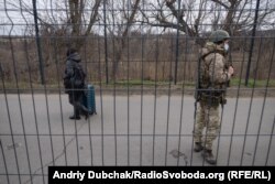 Жінка з валізою рухається в бік підконтрольної Україні території