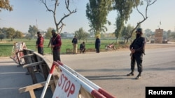 Pakistani soldiers stand guard on a road leading to the cantonment area in Bannu on December 20.