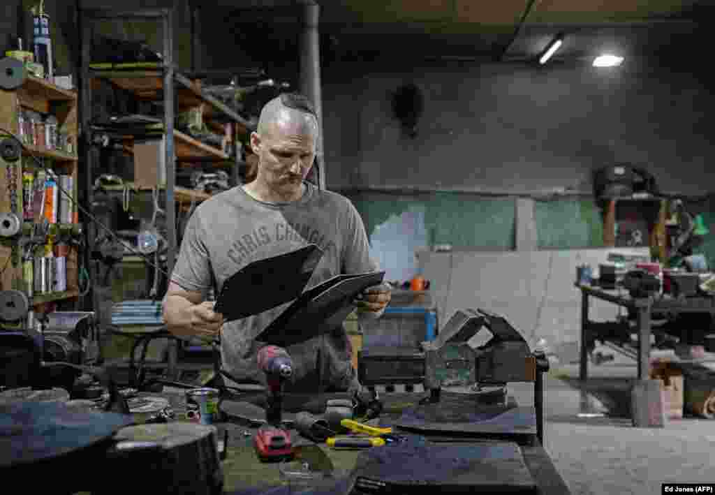Andriy Paliy prepares materials that he uses to produce armor plates at his workshop in Zaporizhzhya in May. Before the invasion, the self-taught blacksmith made swords and medieval suits of armor but now he makes ballistic protection for the Ukrainian military. 