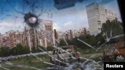 Zapaljeni automobili mogu se vidjeti kroz staklo oštećenog automobila u naselju Saltivka, usred ruskog napada na Ukrajinu, u Harkivu, Ukrajina, 10. maj 2022.