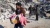 Un bărbat cară trupul unui copil scos dintre dărâmături în orașul Harim, în provincia siriană Idlib, aflată în nord-vestul țării și controlată de rebeli, 8 februarie 2023.