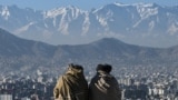 Members of the Taliban sit overlooking the Kabul city at the Wazir Akbar Khan hill in Kabul on January 20, 2022. 22potw03