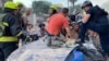 Rescuers release an injured man from a destroyed car at the site of an apartment building hit by a Russian missile strike in Dnipro on June 28.