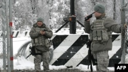 U.S. troops guard the main access checkpoint to the Manas air base.