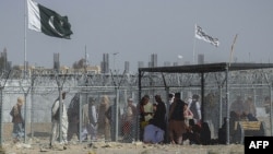 Afghan and Pakistani nationals walk through a security barrier at the Pakistan-Afghanistan border crossing point in Chaman. (file photo)