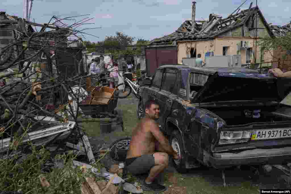 Жители спасают свои вещи из разрушенных домов 
