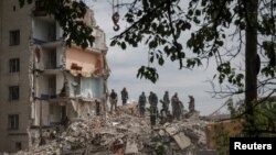 Echipele de salvare intervin, în 10 iulie 2022, la blocul distrus de bombardamentele rusești în Ceasiv Iar.