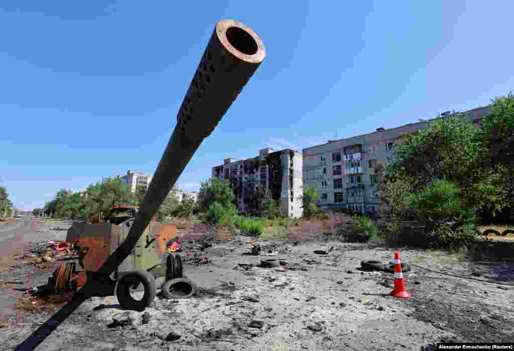 Resturile unui tun anti-tanc MT-12, abandonat în apropierea unor clădiri de apartamente distruse de luptele din ultimele luni.