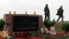 Russia-backed separatist fighters walk past a memorial to victims of the Malaysia Airlines Flight 17 plane crash outside the village of Hrabove in eastern Ukraine.