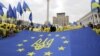 Молодь тримає прапор Євросоюзу з гербом України на майдані Незалежності в Києві, 30 жовтня 2013 року