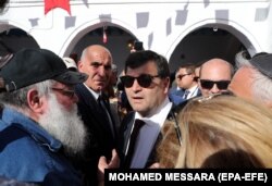 رونی طرابلسی (وسط)، وزیر گردشگری تونس که خود یهودی و از برگزارکنندگان پیشین این مراسم است، امسال به کنیسه جربه رفت.