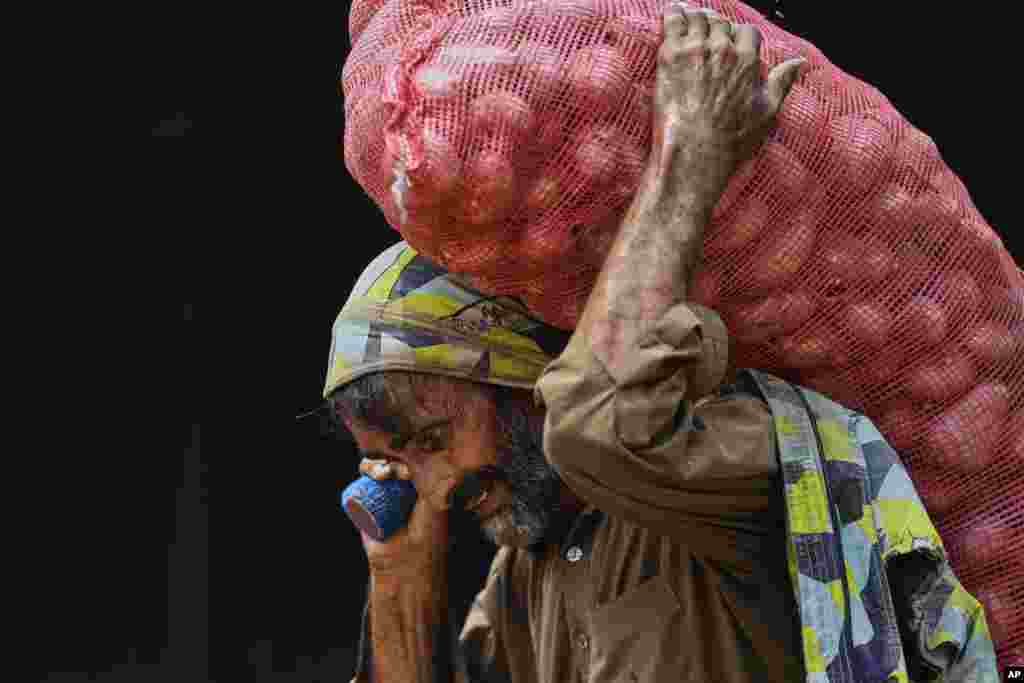 A laborer carries a sack of potatoes at a wholesale vegetable market in Islamabad, Pakistan.