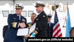 Віцеадмірал Берегової охорони США Макалістер (л), командувач ВМС ЗСУ Воронченко (п) і п'ятий президент Порошенко (позаду) під час урочистої церемонії передачі Сполученими Штатами Військово-морським силам України двох патрульних катерів класу Island. Балтимор, 27 вересня 2018 року