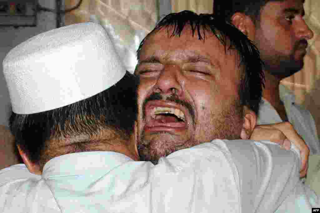 Pakistani men mourn the killing of their relatives at a Peshawar hospital in the wake of the bomb blasts.