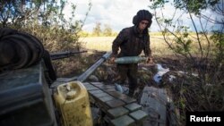Украински войник носи снаряд към танк на позиция близо до фронтовата линия край град Бахмут