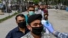 A health worker checks the body temperature of a devotee as a preventive measure against the COVID-19 coronavirus before Friday Prayers at a mosque in Kabul on April 24.