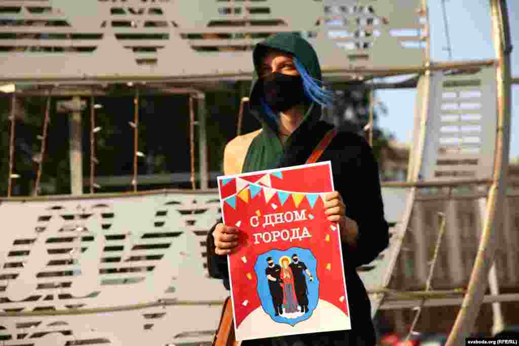 Женщина держит в руках плакат «С Дном города»