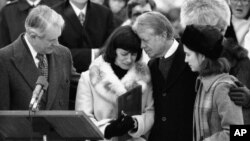 U.S. Secretary of State Cyrus Vance (left) and U.S. President Jimmy Carter comfort Mary Anne Dubs, the widow of slain Ambassador Adolph Dubs, as Dubs' body is returned to Andrews Air Force Base outside Washington, D.C., on February 18, 1979.