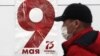 Чоловік у захисній масці на тлі агітаційного плакату з нагоди 75-ї річниці завершення Другої світової війни в Європі, Москва, 5 травня 2020 року