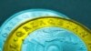 Монеты номиналом 100 и 50 тенге с надписью Qazaqstan на латинице 