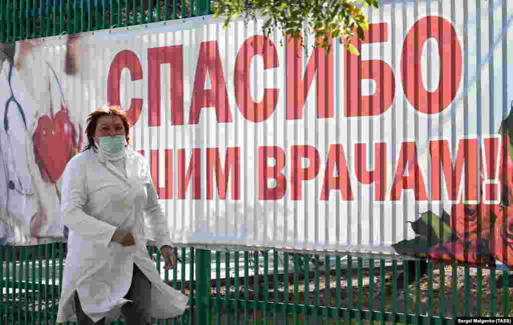 Медработник проходит мимо банера «Спасибо нашим врачам!» около Судакской городской больницы