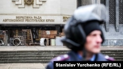 Співробітник МВС біля будівлі кримського парламенту в Сімферополі, який захопили «невідомі озброєні люди», 27 лютого 2014 року