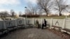 Dve Beograđanke na šetalištu u glavnom gradu Srbije, sa maskama na licu, sede ispred ispisane poruke "korona", u jeku pandemije, februara 2021. 