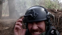 RFE/RL correspondent Maryan Kushnir reacts as Ukrainian forces fire artillery toward Russian positions near Kupyansk in the Kharkiv region. 