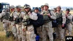 Georgian soldiers carry their gear upon arrival from Iraq at Tbilisi airport on August 11.