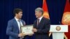 Президент Алмазбек Атамбаев 17-Азия оюндарынын коло байгесинин ээси Догдурбек уулу Эламанга (эркин күрөш) акчалай сыйлыктын сертификатын тапшырууда. 22-октябрь, 2014-ж. 