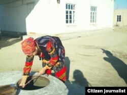 Buxorodagi qishloqlardan birida ayol quduqdan suv tortmoqda. Noyabr, 2012 - yil.