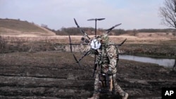 Ruski vojnik nosi ukrajinski dron, 25. marta 2024.